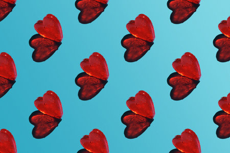 A repeating heart pattern on a blue background with a sharp shadow.