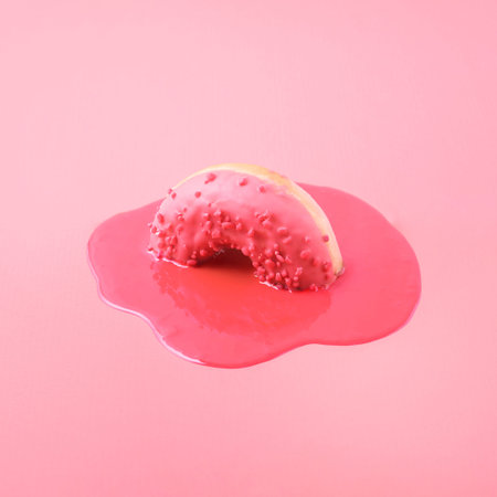 Creative food concept. Pink donut melts on a pink background.