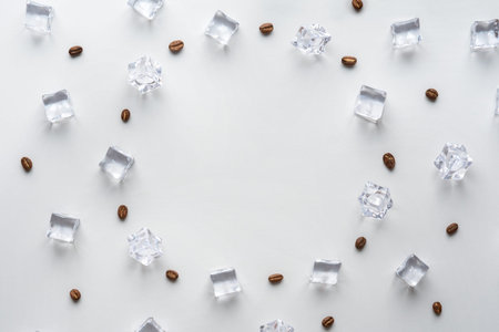 Creative concept of iced coffee on a gray background. Coffee beans with ice cubes and with copy space.の写真素材