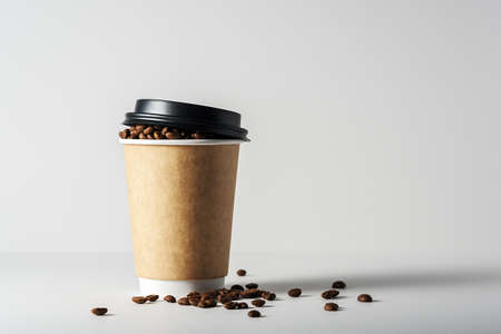 Mock-up of a coffee cup on a gray background with scattered coffee beans.の写真素材