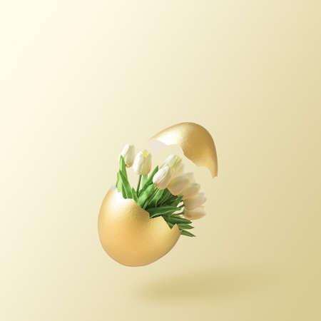 Easter creative layout on a beige background. Easter egg with a bouquet of tulips with an empty space.の写真素材