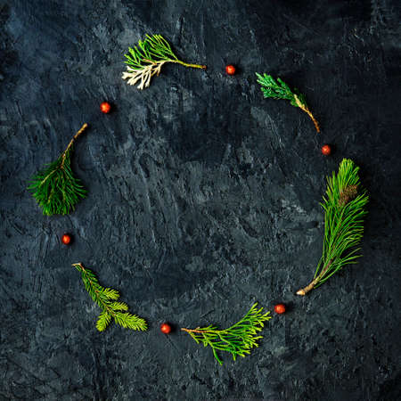 Christmas wreath made of various pine branches on a dark concrete background. christmas layout.の写真素材