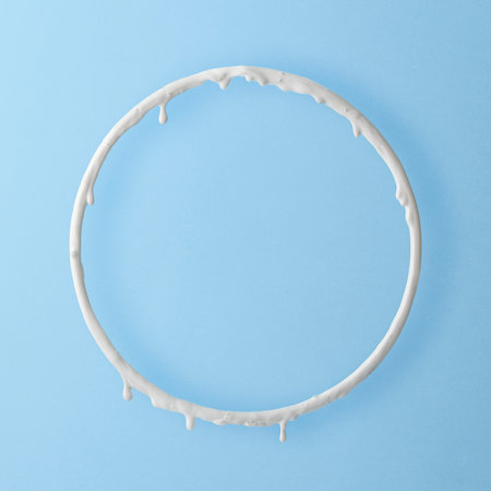 Round frame with white paint drips on a blue background. creative layout.の写真素材