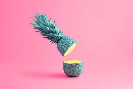 creative food concept. Blue cut pineapple falls on a pink background.の写真素材