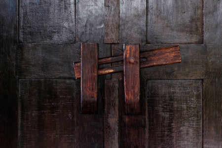Old dark door closed with a wooden latch. close-up.の写真素材