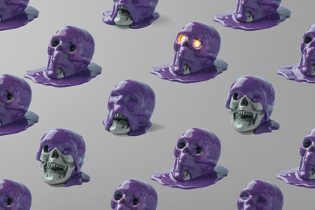 Creative pattern of skulls and purple paint on a gray background. Halloween concept.の写真素材