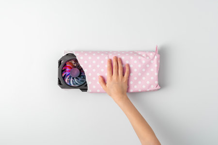 Creative gift concept. Child's hand picks up a gifted graphic card wrapped in pink gift paper on a blue background. Top view.の写真素材