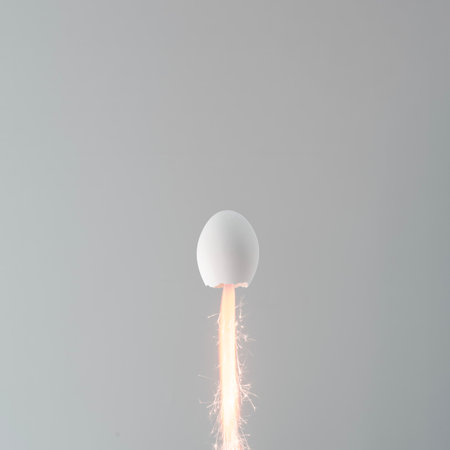 Creative minimalistic easter concept. White Easter egg in the shape of a rocket flies with flames on a gray background with copy space.の写真素材