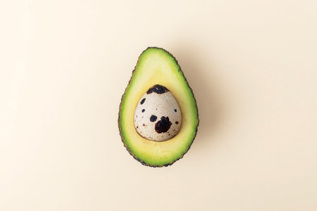 Easter Concept. Egg in cut avocado on beige pastel background.の写真素材