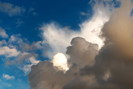 Dramatic clouds against a bright blue sky, large clouds with sunlight highlighting them