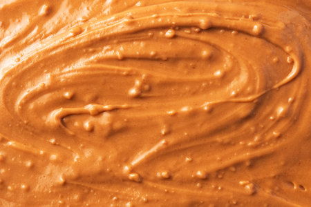 Abstract close-up of creamy peanut butter texture with swirling patterns
