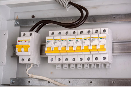 Close-up of circuit breaker panel with yellow switches in distribution boxの写真素材