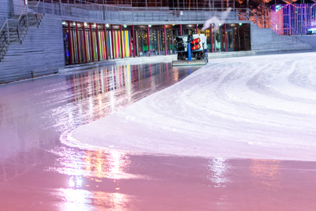 Ice resurfacing machine polishing the rink, reflecting colorful lights and creating a smooth shiny surfaceの写真素材