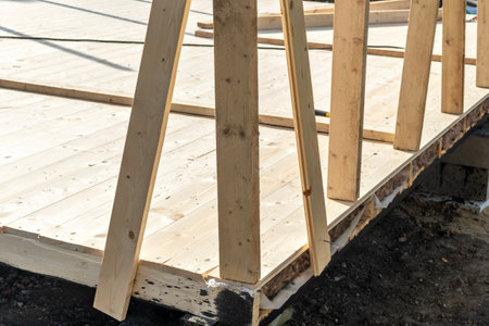Close-up of vertical wooden beams supporting a building foundationの写真素材