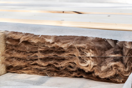 Layered mineral wool insulation between wooden beams with vapor barrier protection
