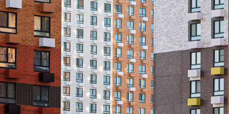 Colorful modern apartment building facade with repeating windows and geometric balconies forming...