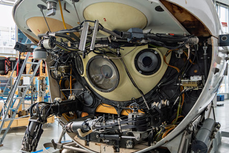 Front view of a complex deep-sea submersible with exposed mechanical arms, wires, and round observation windows, showcasing advanced underwater technology in a scientific laboratory.の写真素材