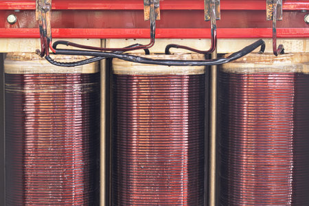 Close-up of industrial copper coils in a power transformer reveals intricate winding patterns, highlighting essential elements of modern electrical engineering.の写真素材