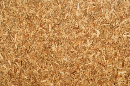 Closeup view of oriented strand board (OSB) surface with chaotic wood chips texture, suitable for construction, design, or background use.の写真素材