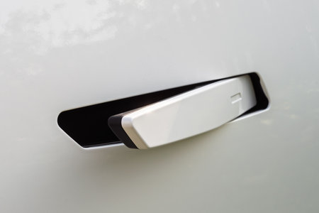 Automatic car door handle extends from glossy white body, demonstrating luxury, high-tech comfort, and modern innovation.の写真素材