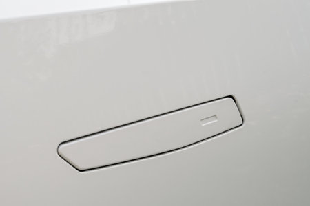 Flush car door handle sits seamlessly in glossy white body, highlighting minimalism, innovation, and sleek automotive design.の写真素材