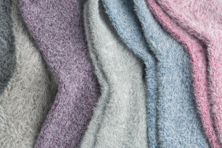 Close-up of soft fluffy pastel socks shows delicate texture and gentle colors, evoking warmth, relaxation, and cozy winter moments.の写真素材