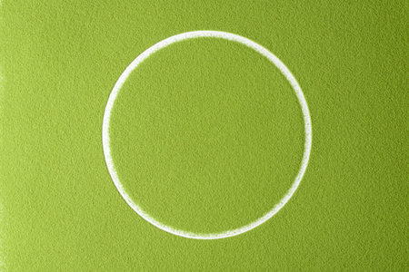 Bright green matcha powder surface with a clean white circle in the center creates a minimalist and modern abstract background.の写真素材