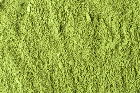 Even layer of crushed matcha powder with mixed granules forms monochrome texture for packaging, menu graphics, posters and backdropsの写真素材