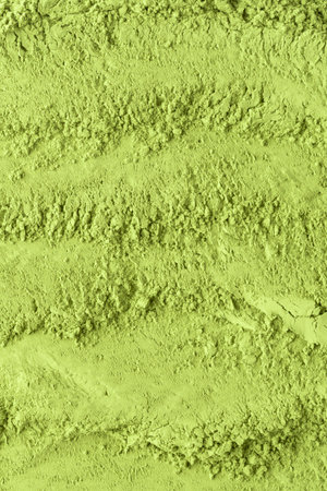 Rough textured green matcha powder surface creates a natural background with rich organic feel.の写真素材