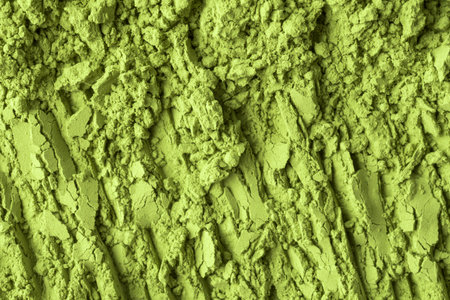 Coarse clusters of matcha powder cover ridged base forming green terrain texture for healthy food ads, cosmetic labels, eco packagingの写真素材