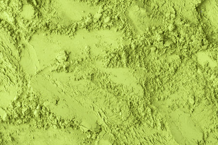 Finely ground matcha powder with uneven texture forms a natural abstract pattern, perfect for culinary, health, and minimalist backgrounds.の写真素材