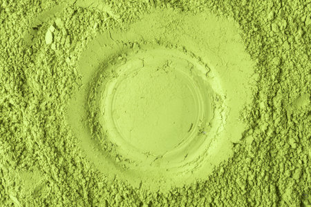Round imprint in matcha powder with granular border forms striking texture for logo mockups, packaging, ads and modern backgroundsの写真素材