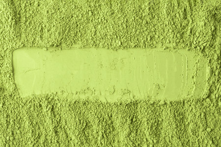 Horizontal stripe is drawn through vibrant matcha powder, dividing fine and coarse textures, perfect for product design and branding.の写真素材