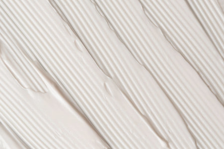 White cosmetic cream texture with diagonal ribbed lines creates a modern geometric abstract background ideal for beauty branding.の写真素材