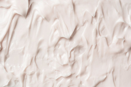 Thick creamy white cosmetic texture with soft peaks and folds forms an organic abstract surface, perfect for skincare advertising visuals.の写真素材