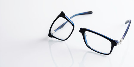 Broken eyeglasses on glossy white surface highlight need for repair service, careful vision care and timely replacement.の写真素材