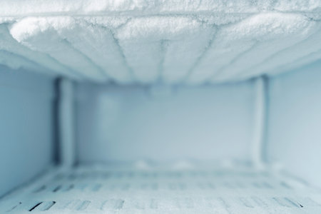 Empty frosty freezer interior with ice buildup and copy space, background for freezing services, cold storage ads and offers.の写真素材
