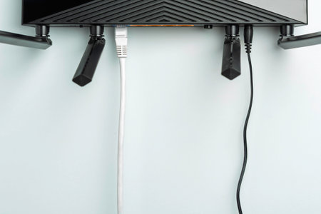 Wireless WIFI router with ethernet and power cables on light background, top border composition with copy space for network text.の写真素材