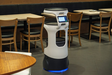 Self-driving waiter robot stands in modern cafe dining area, supports contactless service and faster...