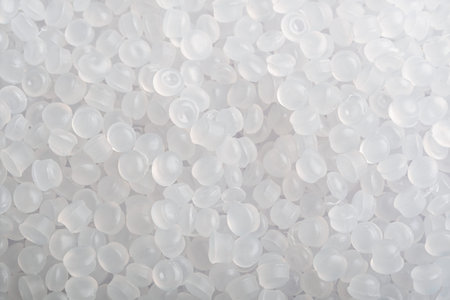 Translucent plastic pellets fill frame in soft light, clean industrial background for polymer production and recycling themes.の写真素材