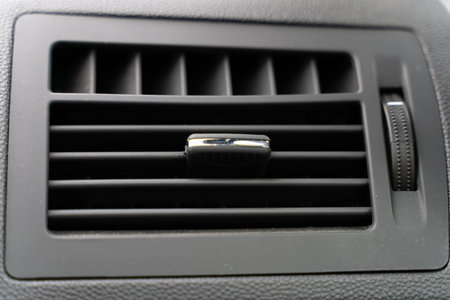 the deflector on the grey panel of the car. the heating and air conditioning system of the car....