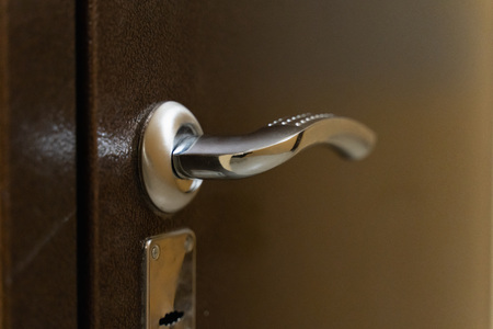 chrome door handle with lock on metal front door close-upの写真素材