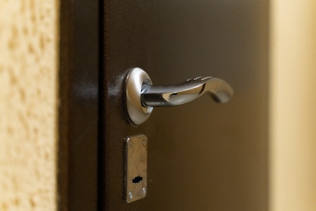 chrome door handle with lock on metal front door close-upの写真素材