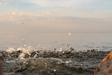 big beautiful splash of water in the sea at sunset. natural desktop backgroundの写真素材