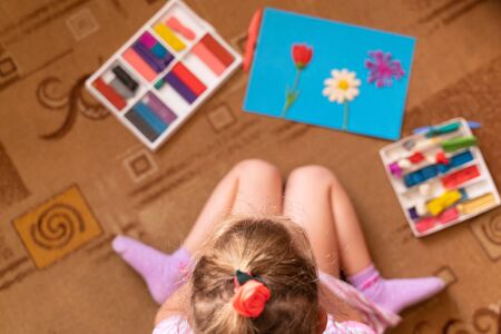 a little girl plays and sculpts from clay. modeling of clay and the development of fine motor skills. Hobbies and interestsの写真素材
