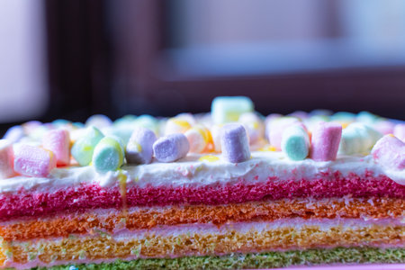 cake with multi-colored cream sprinkled with marshmallows as background