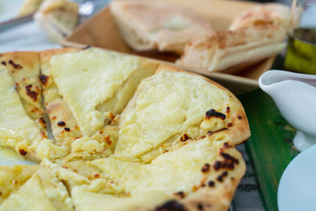 traditional Georgian dish of bread baked with cheese khachapuri close up. template for a cafe or...