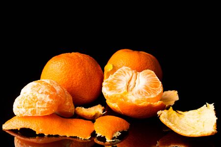 fresh tangerine on a black background with a beautiful reflection close upの写真素材