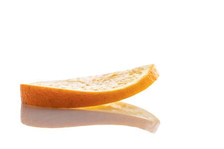 one slice of fresh orange on a white background with a reflection close upの写真素材