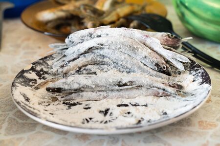 fresh fish of the smelt in the flour. the process of cooking foodの写真素材
